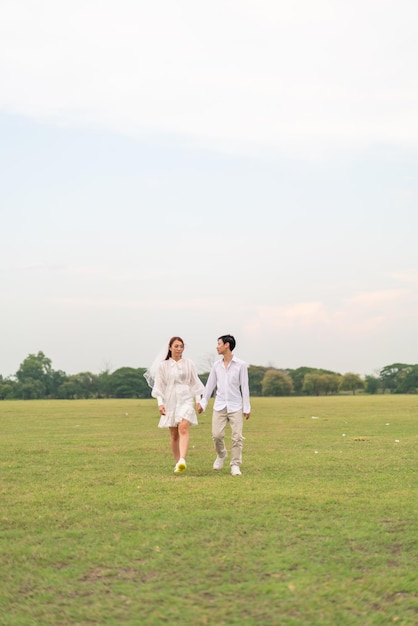 Feliz pareja asiática joven en ropa de novia y novio