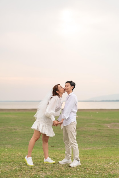 Feliz pareja asiática joven en ropa de novia y novio