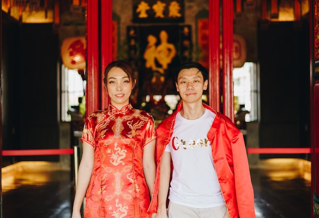 Feliz pareja asiática joven en vestidos tradicionales chinos