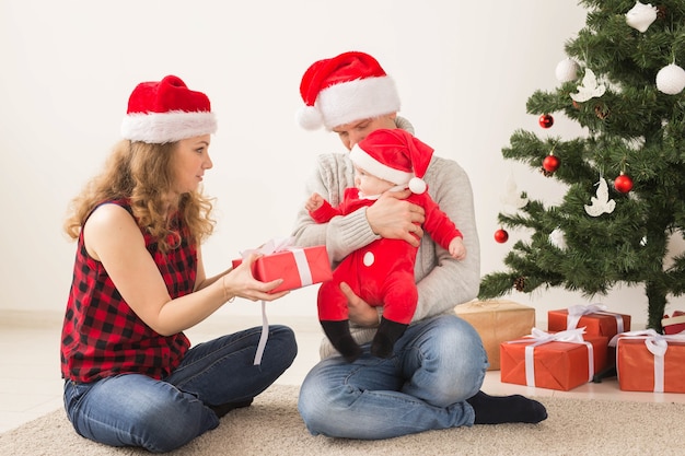 Feliz pareja con bebé celebrando la Navidad juntos en casa.