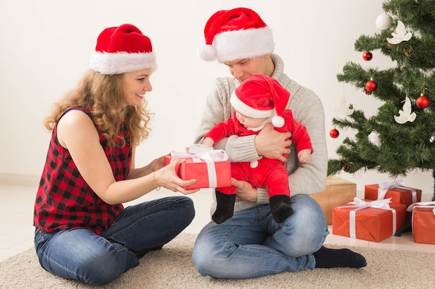 Feliz pareja con bebé celebrando la Navidad juntos en casa