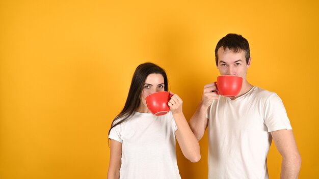 Feliz pareja bebiendo café de tazas grandes