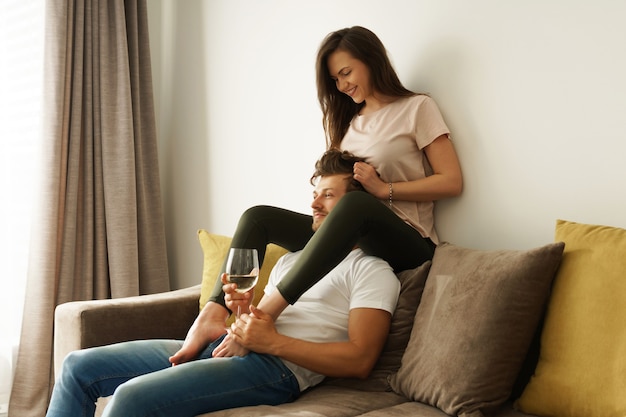 Feliz pareja bebiendo vino y relajándose en casa