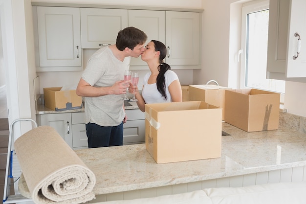 Feliz pareja besándose en la cocina