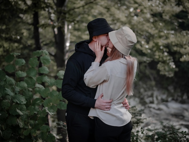 Feliz pareja besándose en el fondo del bosque