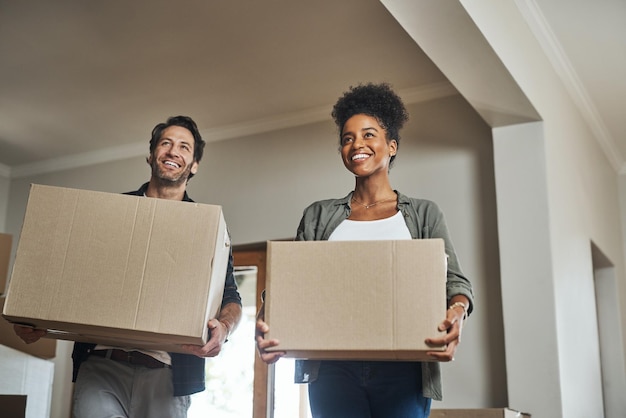 Feliz pareja de bienes raíces y cajas en un nuevo hogar para reubicación, renovación o inversión juntos Emocionado hombre y mujer negra dueña de un apartamento que lleva una caja en la casa que se muda a una propiedad o hipoteca