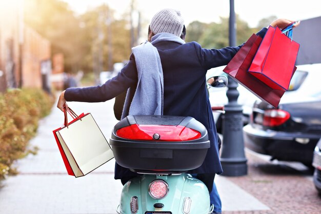 Feliz pareja con bolsas de la compra después de ir de compras en la ciudad sonriendo y abrazándose