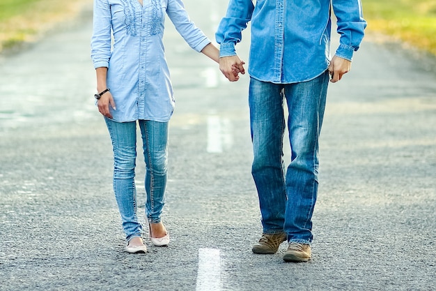 Feliz pareja caminando por la carretera en la naturaleza en el viaje del parque