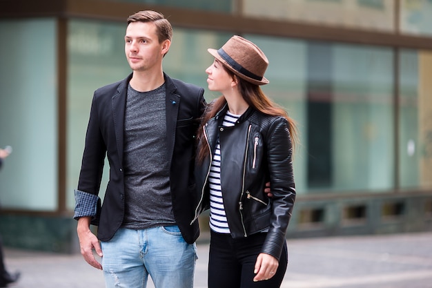 Feliz pareja caminando en europa. amantes sonrientes disfrutando del paisaje urbano con monumentos famosos.