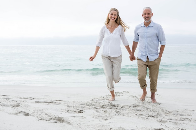 Feliz pareja caminando junto al mar