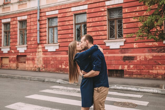 Feliz pareja caminando por el paso de peatones en la ciudad