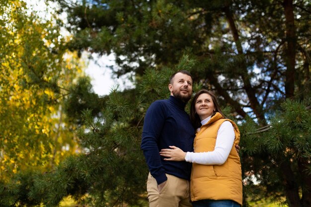 Feliz pareja casada abrazándose en el bosque de otoño