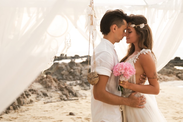 Feliz pareja casada está celebrando su boda en la playa en la isla tropical