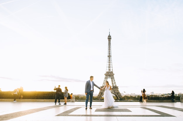 Feliz pareja casada romántica abrazando cerca de la torre Eiffel en París