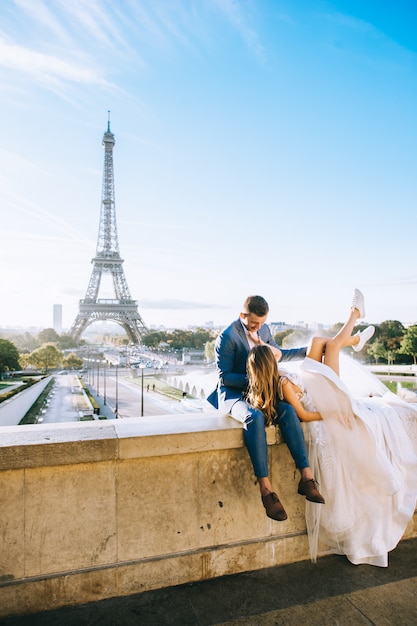 Feliz pareja casada romántica abrazando cerca de la torre Eiffel en París