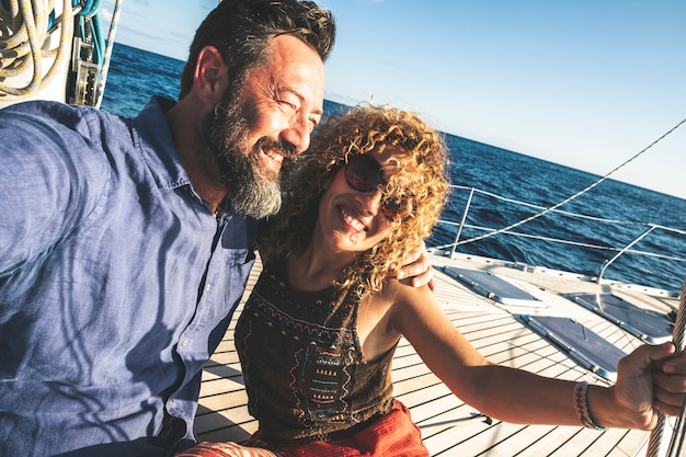 Feliz pareja caucásica adulta juntos en un velero disfrutar de vacaciones