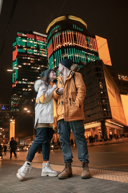 Feliz pareja caucásica alegre y joven se divierten mientras salen juntos al aire libre en una ciudad