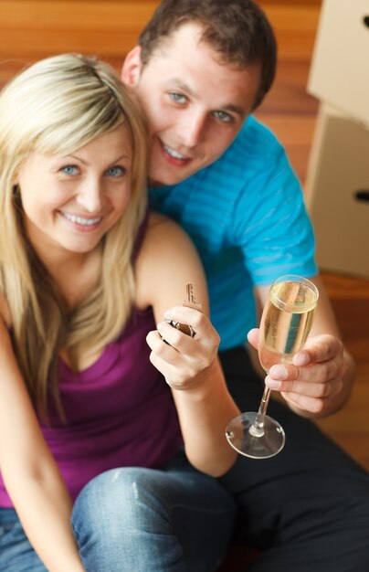 Feliz pareja celebrando la nueva casa con champaña