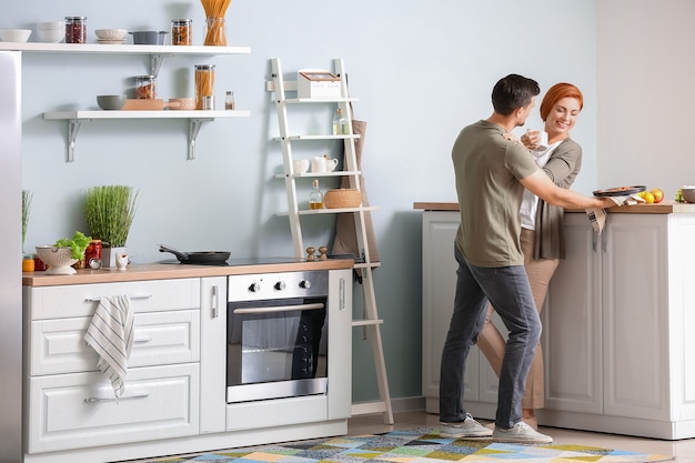 Feliz pareja cocinando juntos en la cocina