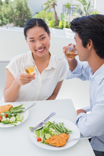 Feliz pareja con una comida junto con vino blanco