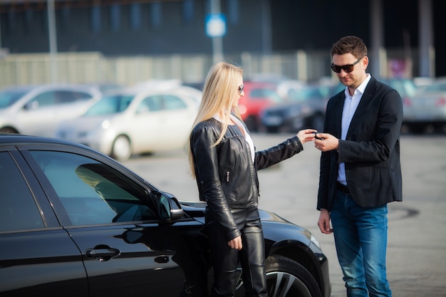 Feliz pareja compra nuevo coche negro moderno