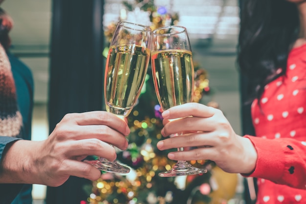 Feliz pareja con copas de champán en la fiesta de Navidad.