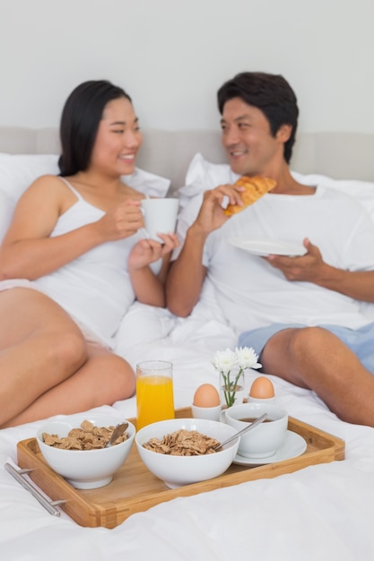 Feliz pareja desayunando en la cama