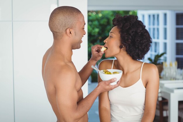 Feliz pareja desayunando en la cocina en casa