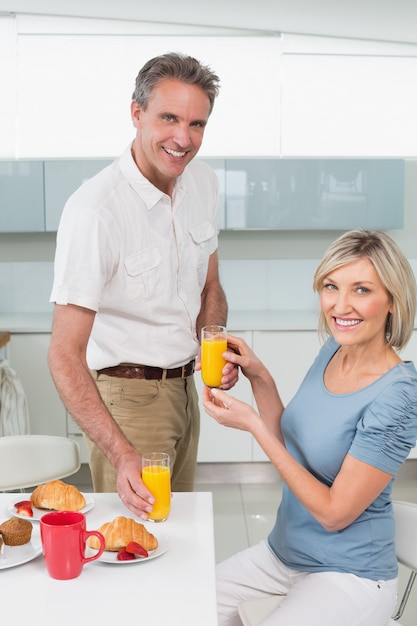 Feliz pareja desayunando en la cocina