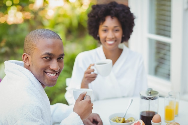 Feliz pareja desayunando en el jardín