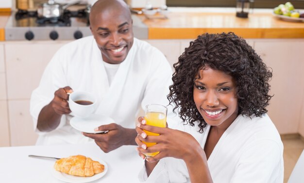 Feliz pareja desayunando juntos en la mesa