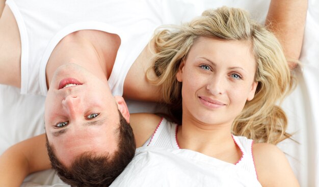 Feliz pareja descansando en la cama