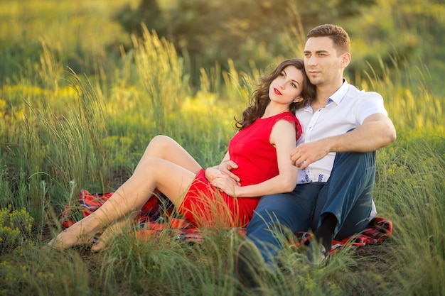 Feliz pareja descansando sobre la hierba en el parque