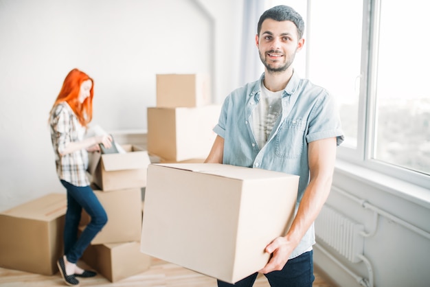 Feliz pareja desembalaje de cajas de cartón, inauguración de la casa. Mudarse a una nueva casa