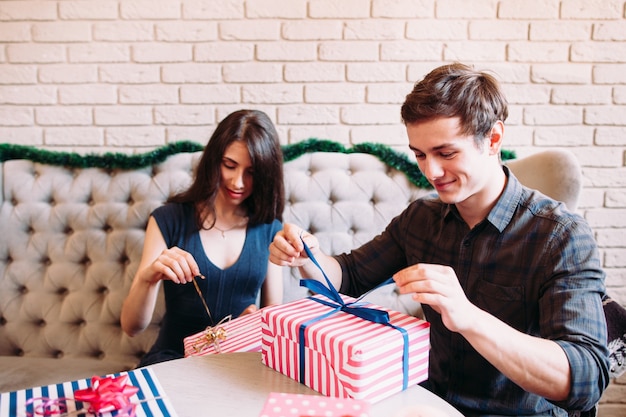 Feliz pareja desembalaje de regalos de Navidad