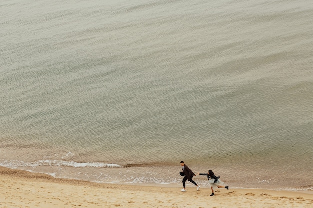 Feliz pareja se divierte al aire libre en la playa de arena.