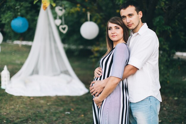 Feliz pareja embarazada posando en la cámara