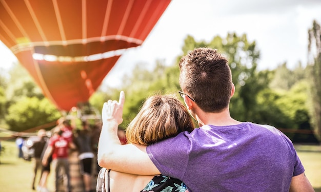 Feliz pareja enamorada en una excursión de luna de miel esperando un paseo en globo aerostático