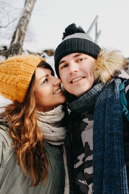 Feliz pareja de enamorados haciendo selfie en el parque natural del bosque en la temporada de frío.