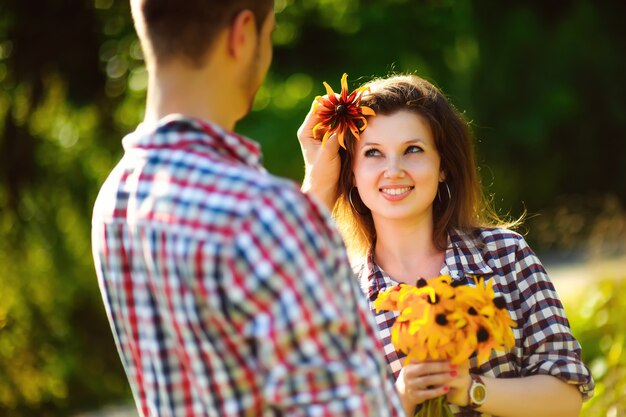 Feliz pareja de enamorados posando con girasoles