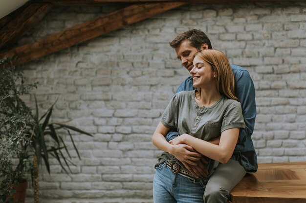 Feliz pareja encantadora joven en la cocina abrazándose unos a otros