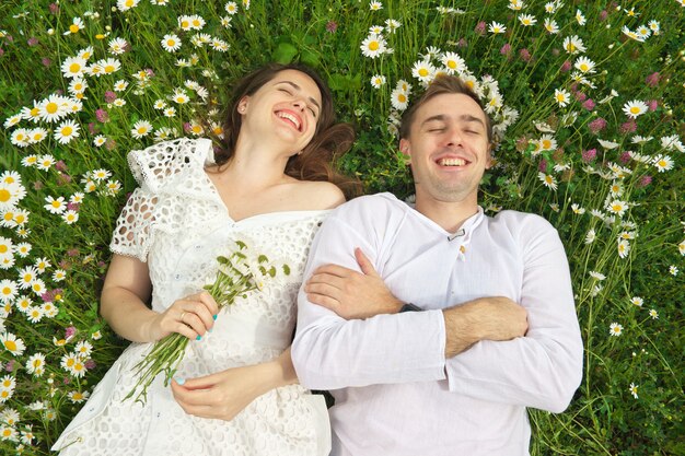 Feliz pareja se encuentran en una flor de manzanilla.