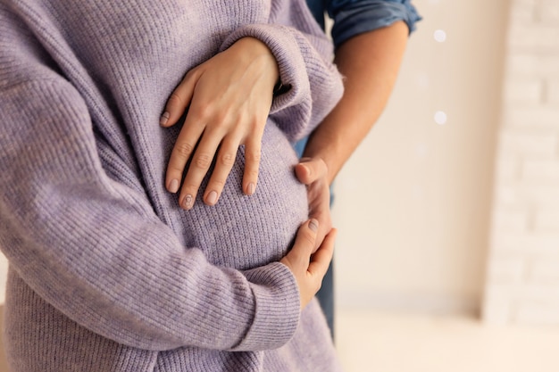 Feliz pareja, esposa y esposo abrazando la barriga