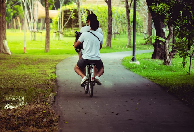 Feliz pareja está en bicicleta en el parque.