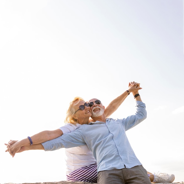 Feliz pareja estirando los brazos en el aire