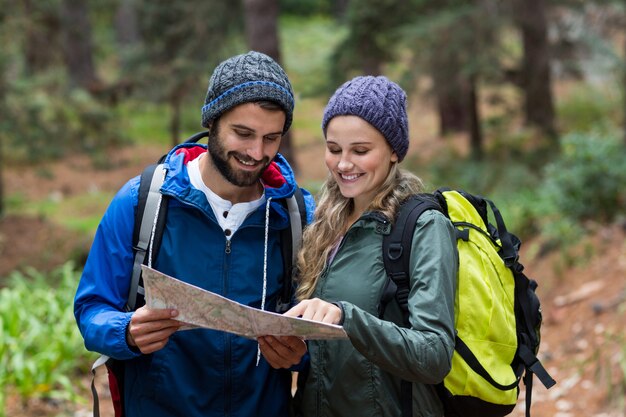 Feliz pareja excursionista mirando el mapa