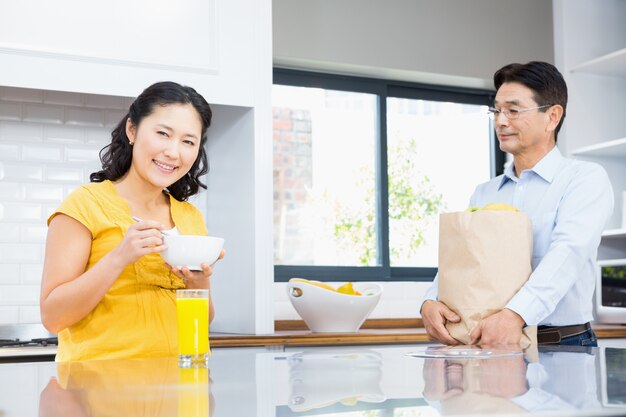 Feliz pareja expectante en la cocina por la mañana