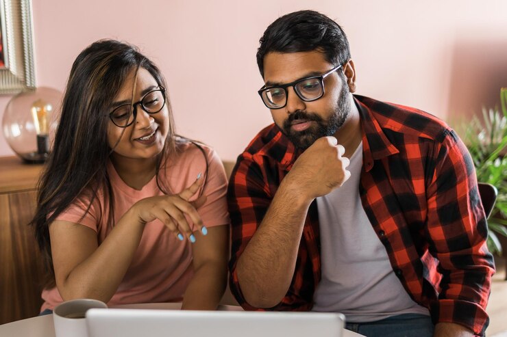 Foto feliz pareja de familia india acurrucarse en el escritorio hacer videollamadas a amigos usando la cámara web de la computadora portátil amando a youn