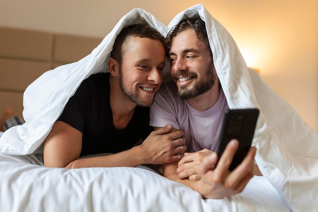 Feliz pareja gay teniendo momentos tiernos en el dormitorio Relación de amor homosexual y concepto de igualdad de género