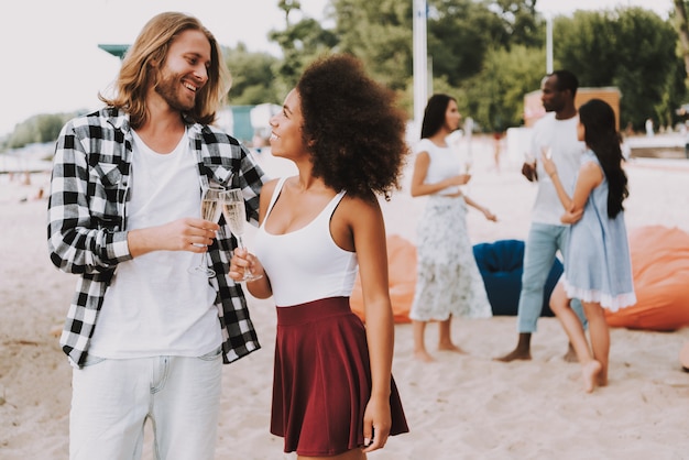 Feliz pareja hipster celebrando en la orilla del verano.